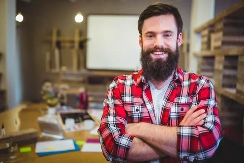 Man standing in creative workshop using laptop with scattered papers, sticky Stock Photos