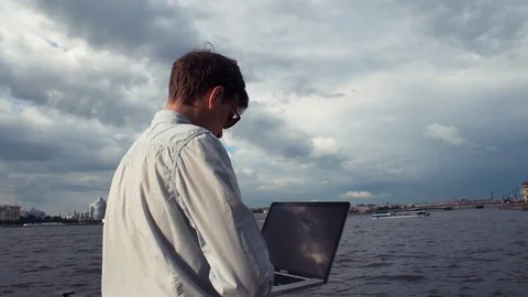 Man standing on deck, using laptop, receiving good news and celebrating success Stock-Footage 77167140