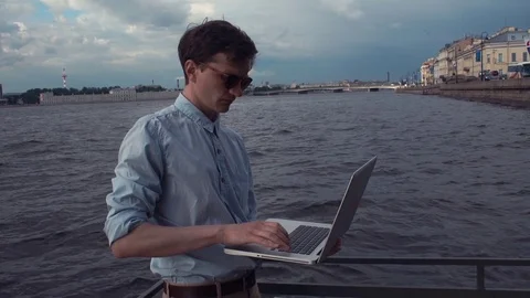 Man standing on deck using laptop receiving good news and celebrating success Stock Footage 77167170