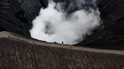 Man standing on edge of active Volcano Mt. Bromo in East Java, Indonesia Stock Footage 129289811