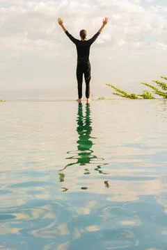 A man standing at the edge of infinity pool Stock Photos