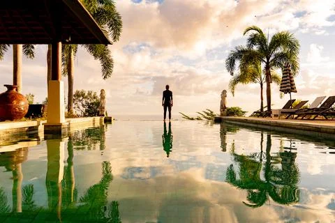 A man standing at the edge of infinity pool Stock Photos