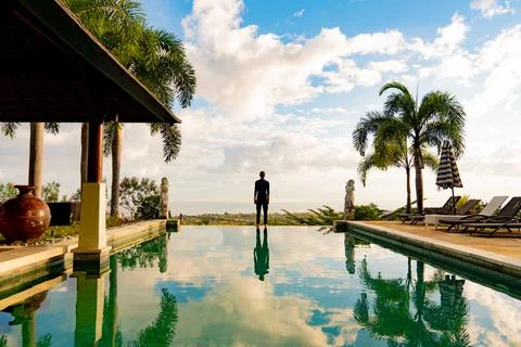 A man standing at the edge of infinity pool Foto stock