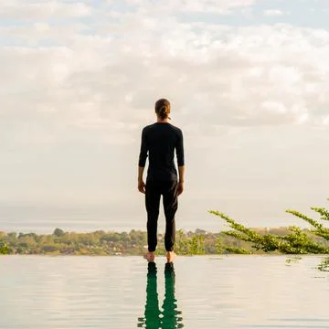 A man standing at the edge of infinity pool Stock Photos