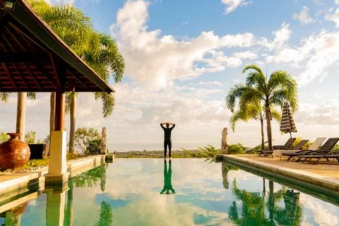 A man standing at the edge of infinity pool Stock Photos