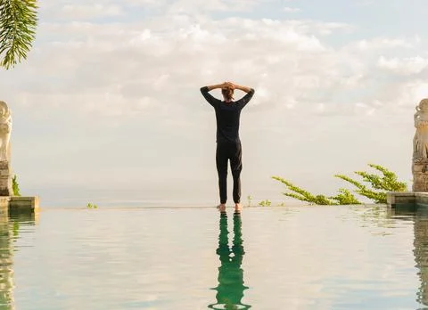 A man standing at the edge of infinity pool Foto stock