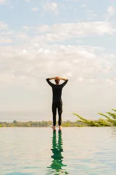 A man standing at the edge of infinity pool Stock Photos
