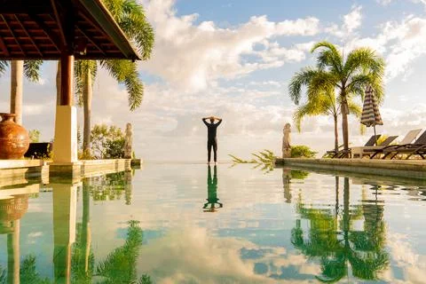 A man standing at the edge of infinity pool Stock Photos