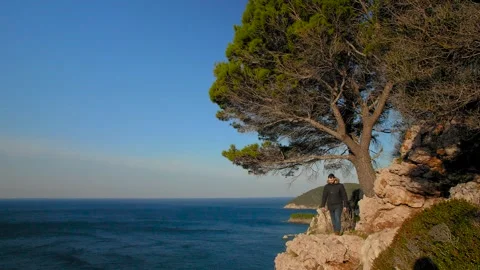 A man standing on the edge of a mountain and looking out to the sea. Montenegro. Stock Footage 273566702
