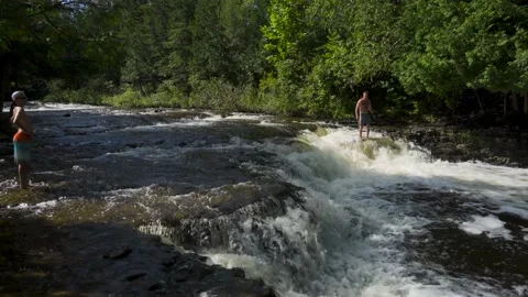 Man standing at edge of small watefall Stockbeeldmateriaal 166598131