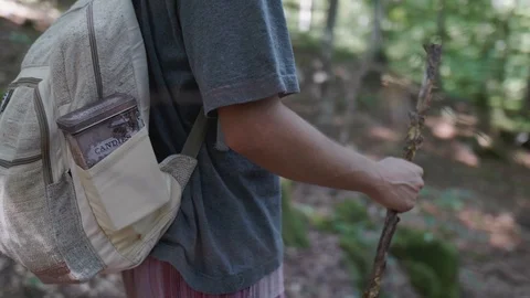Man standing in the forest holding a walking stick Stock Footage 121805826
