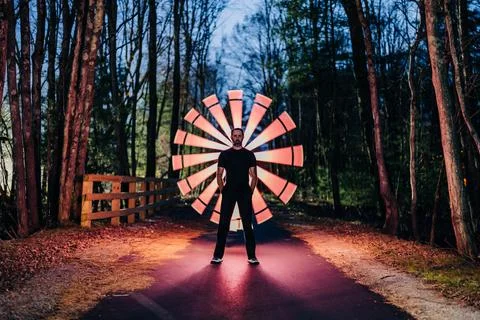 Man standing in forest with a red glowing circular light pattern Stock Photos