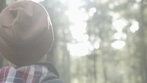 Man standing in forest sunlight in a beanie 4k UNGRADED LOG Stock Footage 101764037