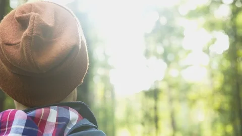 Man standing in forest sunlight in a beanie 4k Stock Footage 102807186
