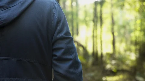 Man standing in forest sunlight in jacket winter 4K Stock Footage 102807311