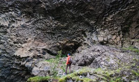 Man standing in front of basalt columns wall in Gjain canyon, Iceland Stock Photos
