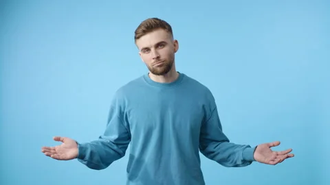 Man standing in front of blue background and waves his hands Video stock 266461981