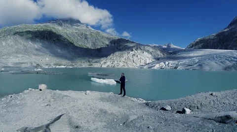 Man standing in front of glacier lake. mountain landscape background Stock Footage 64804949