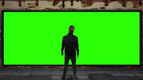 Man Standing in Front of Green Screen Billboard Urban Advertising Mockup Stock Footage 342072696