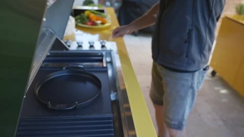 A man is standing in front of a grill, looking at it Video stock 297870440