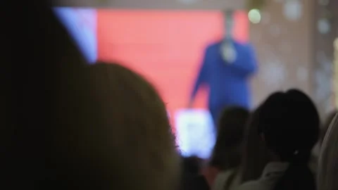 Man is standing in front of a large screen with a microphone Stock Footage 300931871