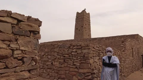 Man standing in front of mosque, Ouadane, Sahara, Mauritania Vídeo Stock 150079921