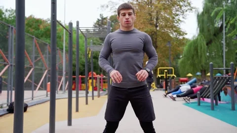 A man is standing in front of a playground in a Stock Footage 265399886