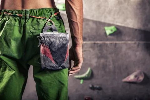 Man standing in front of a practical climbing wall indoor and preparing to .. Stock Photos
