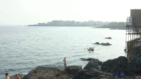 Man standing in front of the sea in Catania, Sicily Stock Footage 80010797