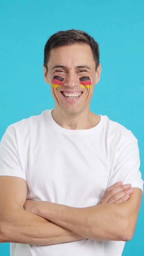 Man standing with german flag painted on face smiling Stock Footage 269774256