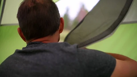 Man standing up getting out of tent exiting camp in Flaming Gorge Utah Stock Footage 120608885