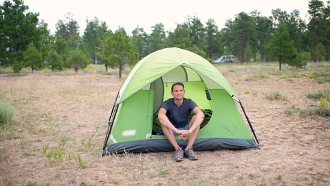 Man standing up getting out of tent camp in Flaming Gorge Utah Stock Footage 120608925