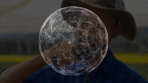 Man standing in grassy field with digital tech sphere remaining center frame and Stock Footage 314687823