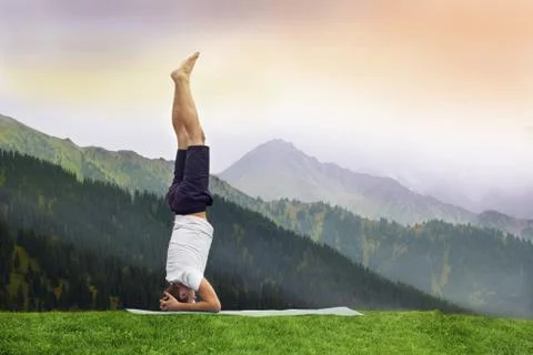 Man standing on her head doing yoga in Himalayan mountain Stock Photos