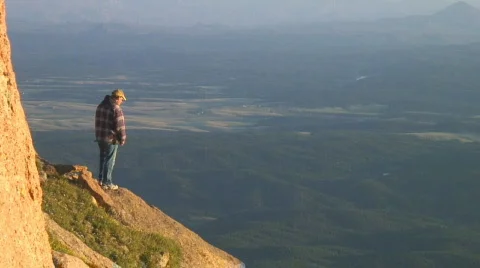 Man standing on high mountain cliff  Stock Footage 281487