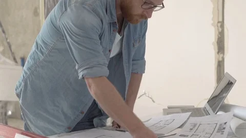 Man standing in his new flat and working on projects, steadycam shot Stock Footage 76493317