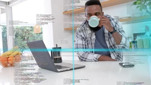 Man standing at island lifting mug sipping while checking laptop for work, tech Stock Footage 333734479