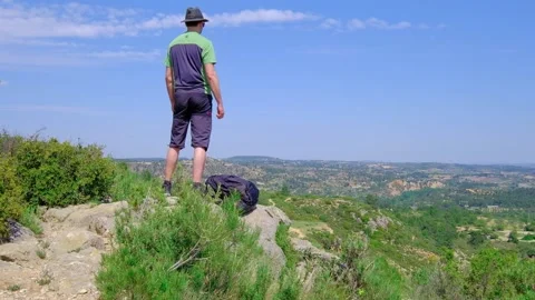 Man is standing with a laying backpack. Hiking in nature. Video stock 202308786