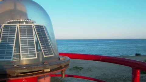 The man is standing on the lighthouse against the backdrop of the sea, leaning Stock Footage