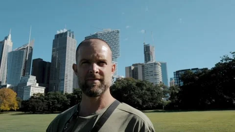 Man standing looking at camera with Sydney downtown backdrop Stock Footage 277888903