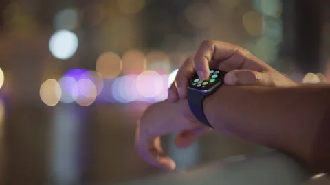 Man standing on the marina and setting up his Men's hand watch.Night city Video stock 204978099