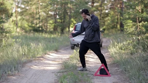 A man is standing in the middle of the forest, his car has broken down Vídeo Stock 158044572