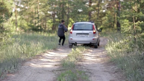 A man is standing in the middle of the forest, his car has broken down Video stock 158044812
