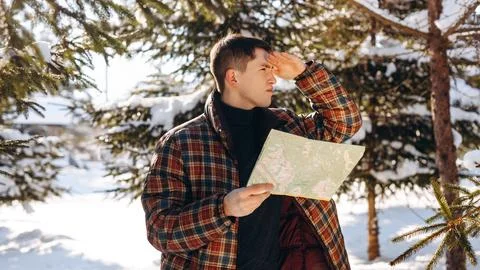 A man standing in the middle of a winter forest looks into the distance Stock Photos