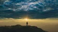 The man standing on a mountain against the bright sun. time lapse 4k or 4k+ Resolution