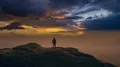 The man standing on a mountain against a picturesque cloud stream. time lapse 4k or 4k+ Resolution