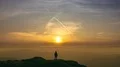 The man standing on a mountain on the bright sunset background 4k or 4k+ Resolution