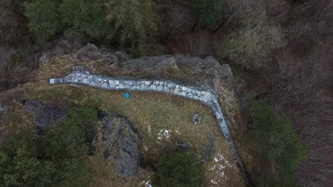 Man Standing on Mountain Cliff Edge With Scenic Alpine View Видео 331742514