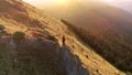 The man standing on the mountain cliff on the sunset background 4k or 4k+ Resolution