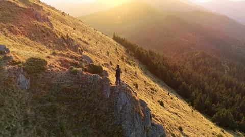 The man standing on the mountain cliff on the sunset background Vídeos de archivo 95459987